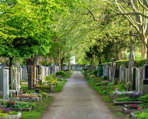 Bergungshaus Schlage; Friedhof mit Gräbern und grünen Bäumen für ein würdiges Abschiednehmen.